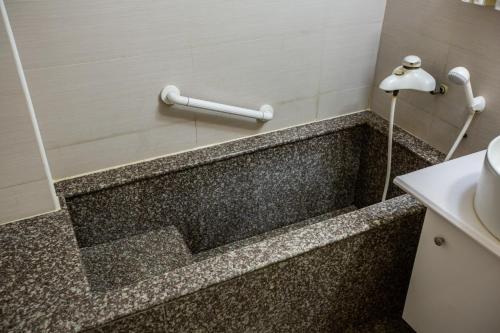 Wenquan东台温泉饭店的浴室配有浴缸及盥洗盆