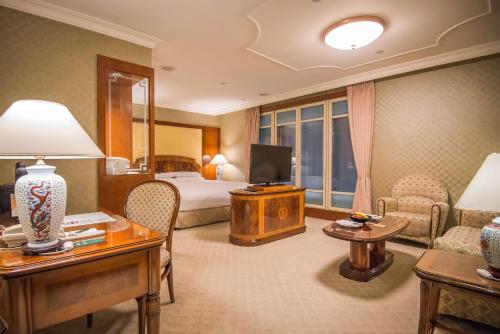 台北台北长荣桂冠酒店的酒店客房,配有床和电视