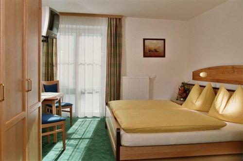 拉德施塔特陶尔努青年旅舍的一间卧室配有一张床和一张书桌