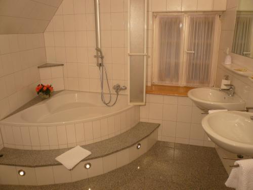 费尔贝特Elektro-Hotel Rosenhaus GmbH的带浴缸和盥洗盆的浴室