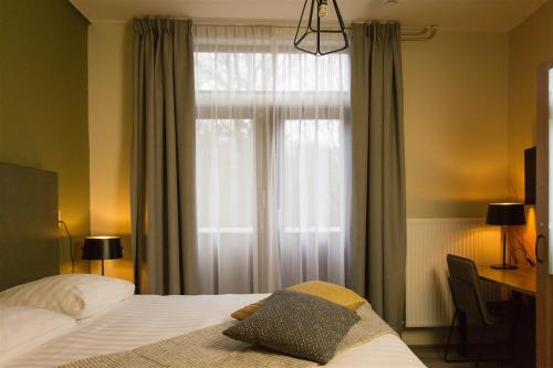 东福尔讷马里昂住宿加早餐酒店的一间卧室配有床和带窗帘的窗户