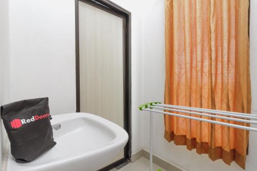 班贾尔马辛RedDoorz Syariah near RSU Suaka Insan Banjarmasin的浴室设有位于水槽顶部的黑袋