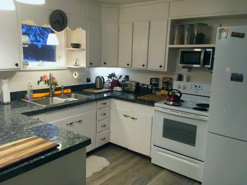费尔班克斯比利的背包客旅舍的厨房配有白色橱柜和白色冰箱。