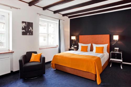 杜塞尔多夫Gildors Hotel Atmosphère的一间卧室配有一张大床和一把椅子