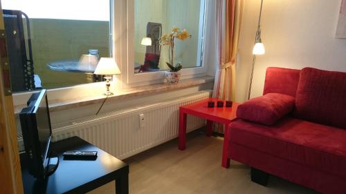布劳恩拉格Ferienwohnung "Traumblick" - Selbstversorger的客厅设有红色的沙发和窗户。