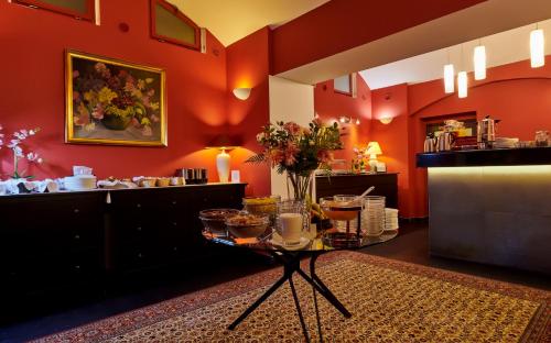 布拉格精品酒店的一间红色墙壁的房间和一张带食物的桌子