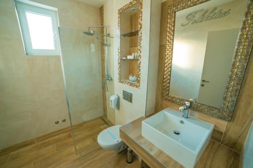 拉克塔希Motel Felikitas的一间带水槽、卫生间和镜子的浴室