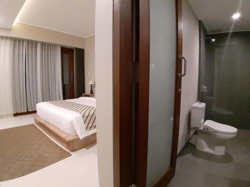 乌布Kyumari的一间卧室配有一张床,浴室设有卫生间
