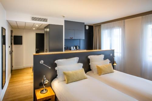 鸽林巴黎拉德芳斯贝斯特韦斯特酒店的配有两张枕头的床的酒店客房