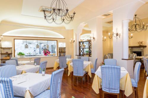 波西塔诺La Taverna del Leone的餐厅设有蓝色的桌椅和窗户。
