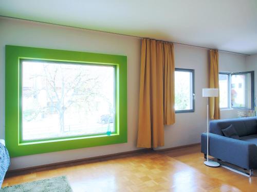 GeislingenKünstlerhaus Arthotel的客厅设有绿色窗户和沙发