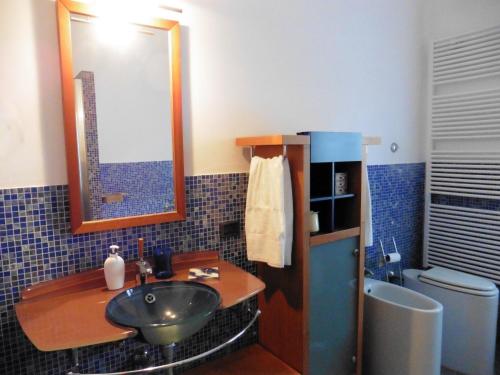 波焦阿卡伊阿诺Appartamento il Veggio的浴室配有盥洗盆、镜子和浴缸