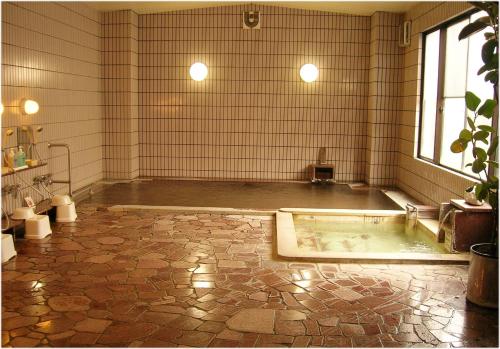 大町市梦之汤酒店的一间位于客房中间的大浴室,配有浴缸
