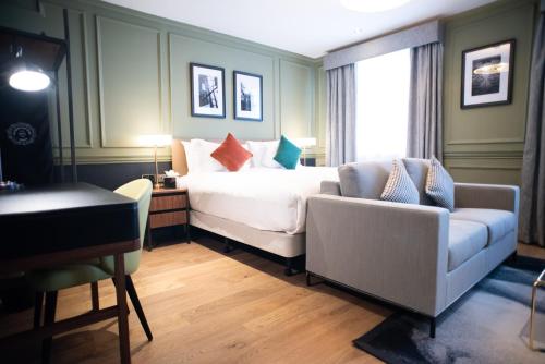 伦敦Counting House的一间卧室配有一张床、一张沙发和一把椅子