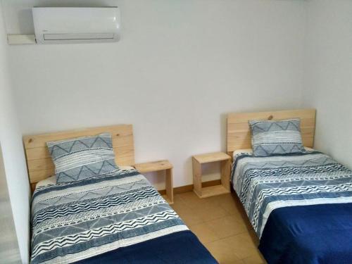 奥尔塔-德圣胡安Casa del Pintor的一间卧室配有两张带蓝白色床单的床