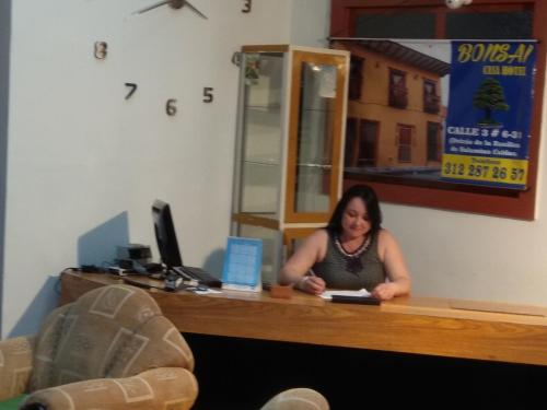SalaminaBonsai Hotel Salamina Caldas的坐在办公室桌子上的女人