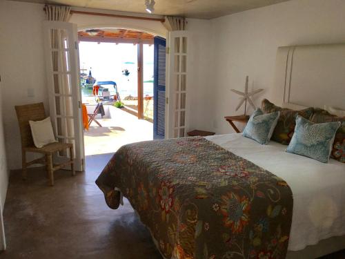 Praia VermelhaCasarao da Praia的一间卧室设有一张床,并有通往庭院的门