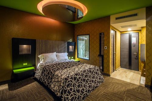 墨西哥城HOTEL ZARAGOZA INN BOUTIQUE的一间卧室设有一张床和绿色的墙壁