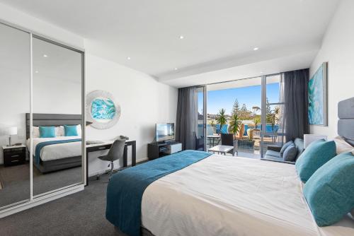 麦夸里港麦觉理港曼特拉码头酒店的酒店客房设有一张大床和一张书桌。