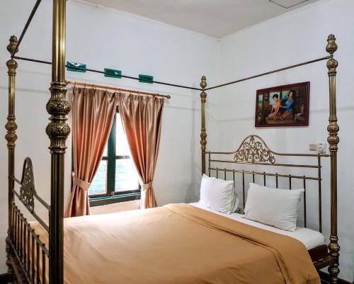 日惹达林加美兰酒店的一间卧室设有四柱床和窗户。
