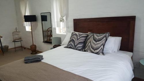 彼得马里茨堡loft 33的卧室配有白色的床和木制床头板