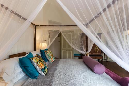 科伦坡Prana Home的卧室配有带枕头的天蓬床