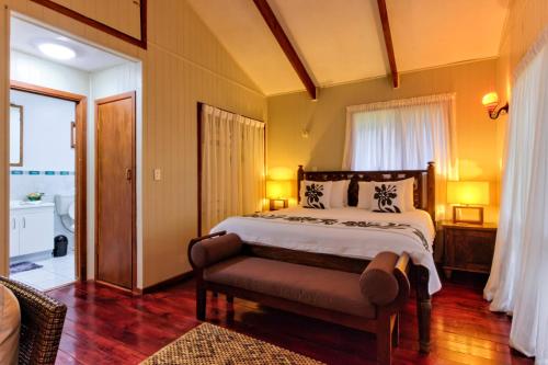 拉罗汤加特阿瓦海滩度假屋的一间卧室配有一张床和长凳