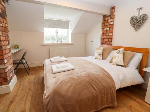 雷克瑟姆Commonwood Cottage的一间卧室配有一张大床和两条毛巾