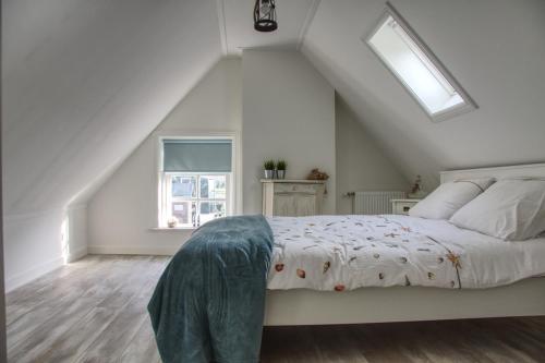 ModdergatHuisje de Eersteling的白色卧室设有一张带窗户的床