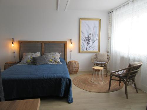 维讷伊Les Bordes的一间卧室配有一张床、一把椅子和一张桌子