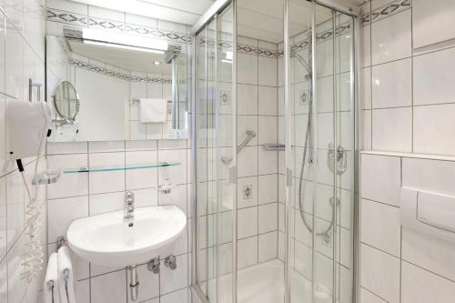 奥伯斯特多夫Hotel garni Kappeler-Haus的白色的浴室设有水槽和淋浴。