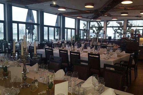 沃尔姆斯阿尔特斯·鲁德豪斯旅馆的一间设有白色桌椅和窗户的用餐室