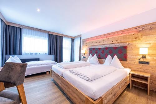 萨尔巴赫Hotel Garni Siegmundshof - inclusive Joker Card im Sommer的酒店客房,配有两张床和椅子