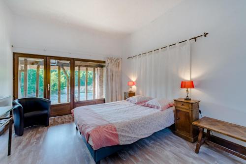Saint-Priest-sous-Aixe穆林杜马耶度假屋的一间卧室配有一张床、一张书桌和一个窗户。