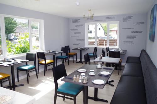 格伦科Strathassynt Guest House的用餐室设有桌椅和窗户。
