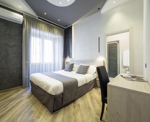 那不勒斯那不勒斯贝拉酒店的一间卧室配有一张床、一张桌子和一个窗户。