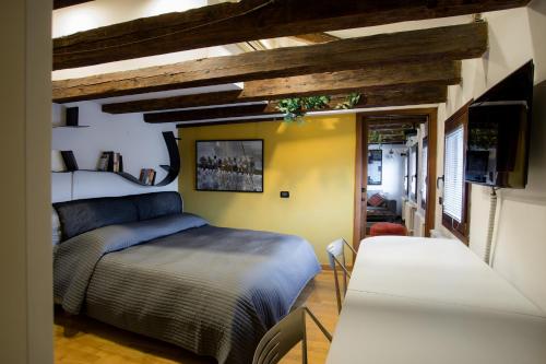 威尼斯威尼斯玛格丽特楼酒店的一间卧室配有一张床,并在一间客房内配有电视。