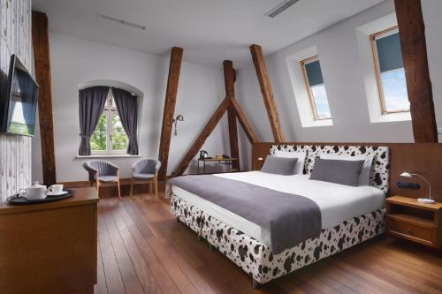 格丁尼亚Relais & Châteaux Hotel Quadrille - Adults Only的卧室配有一张床和一张桌子及椅子
