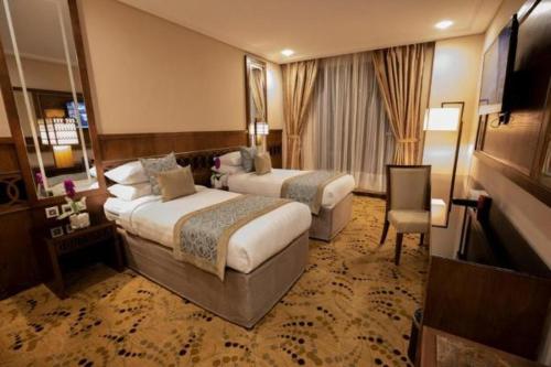 麦加Violet Al Azizia Hotel的酒店客房设有两张床和电视。