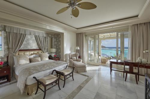 Canouan卡努安文华东方酒店的一间卧室设有一张大床,享有海景