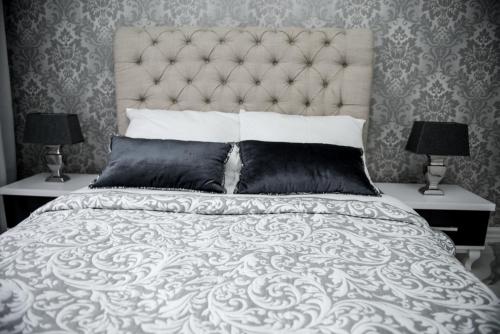 皮拉Glamour Apartments的一间卧室配有一张带两盏灯的大型白色床。