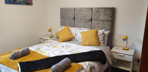 柯科迪The Beach Apartment, near Outlander location的一间卧室配有一张带黄色枕头的大床