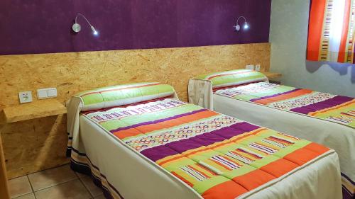 阿尔玛格鲁Hs San Francisco - CÉNTRICO的紫色和紫色的客房内设有两张床。