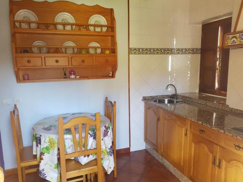 ArancedoApartamentos Rurales Casa Caleya的厨房配有水槽和桌椅