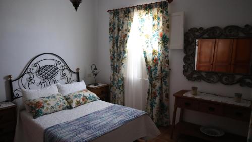马佐LA CASITA DEL JEBRERO的一间卧室配有床和带窗帘的窗户