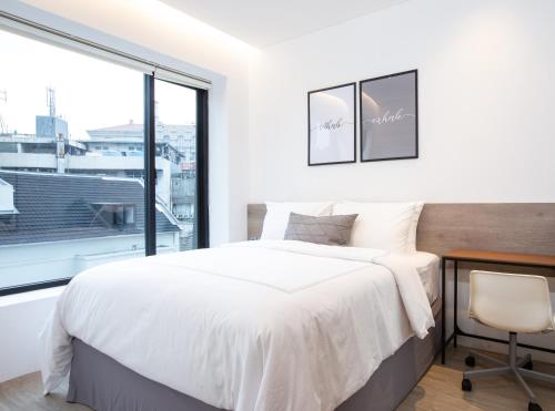 雅加达Ariama Serviced Residence的白色的卧室设有床和窗户