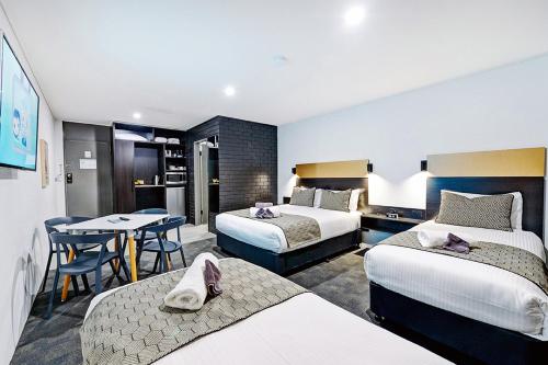 科夫斯港CBD Motor Inn的酒店客房设有两张床和一张桌子。