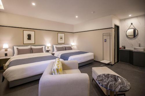昌原市Browndot Hotel Masan Odong的酒店客房,设有两张床和一张沙发