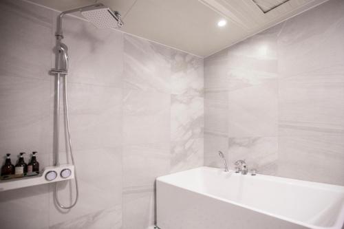昌原市Browndot Hotel Masan Odong的白色的浴室设有淋浴和浴缸。