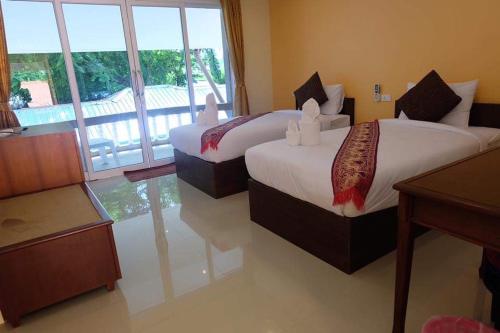 查汶family guesthouse chaweng的酒店客房设有两张床和大窗户。
